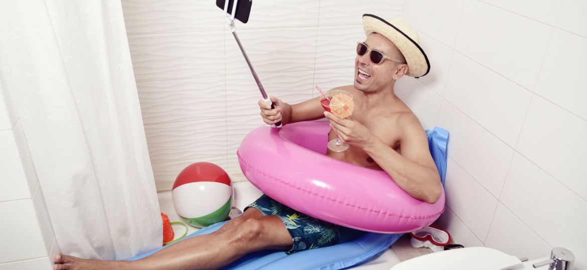 man with swim ring taking selfie in the bathroom